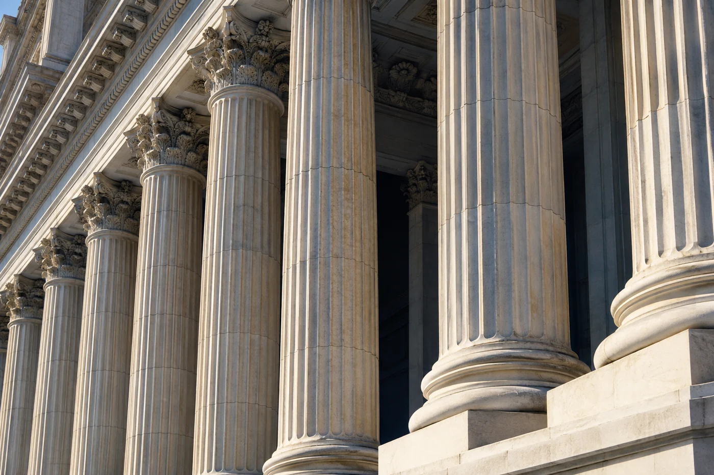 Sunlight and deep shadows across classical courthouse columns